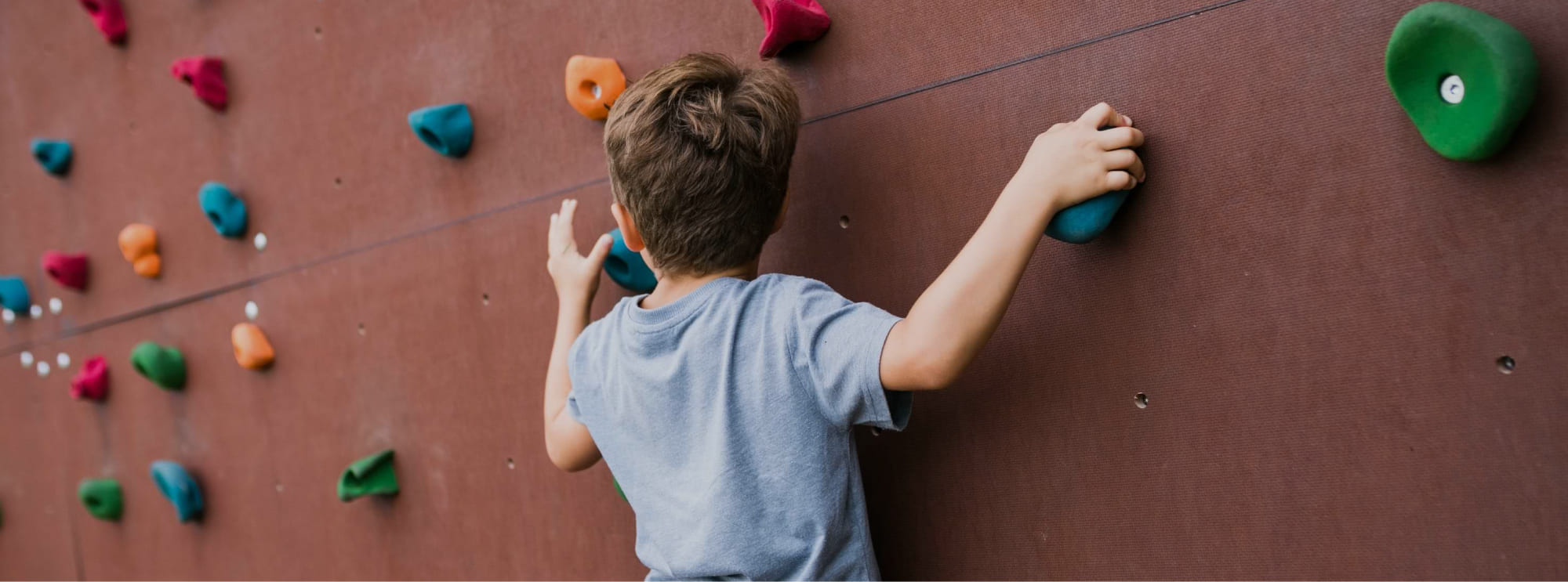 Klettern auf der Boulderwand in der Sportanlage des Jugendhotels Markushof in Österreich