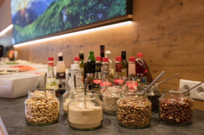 Salatbar mit Dressings und N&uuml;ssen